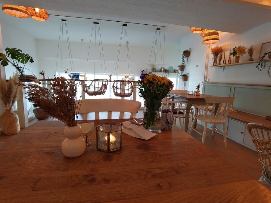 Gemütliche Schaukel-Lounge mit Holztischen und Kissen im Tjorvi's Kiel